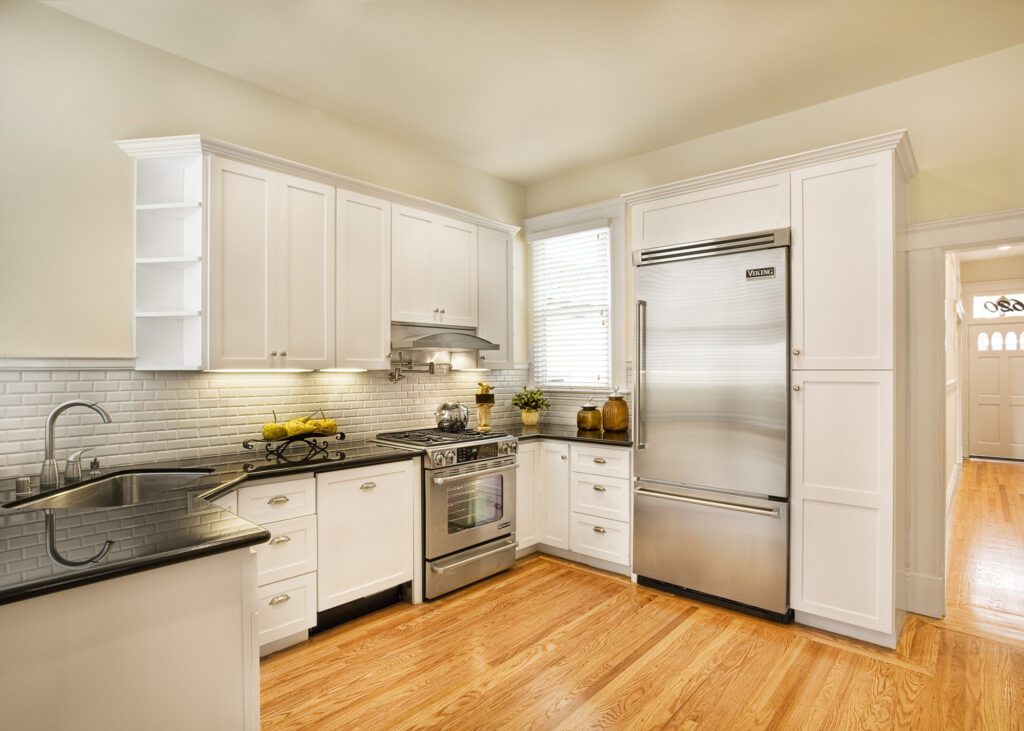 Bright kitchen with white cabinetry, stainless steel appliances, and hardwood floors.