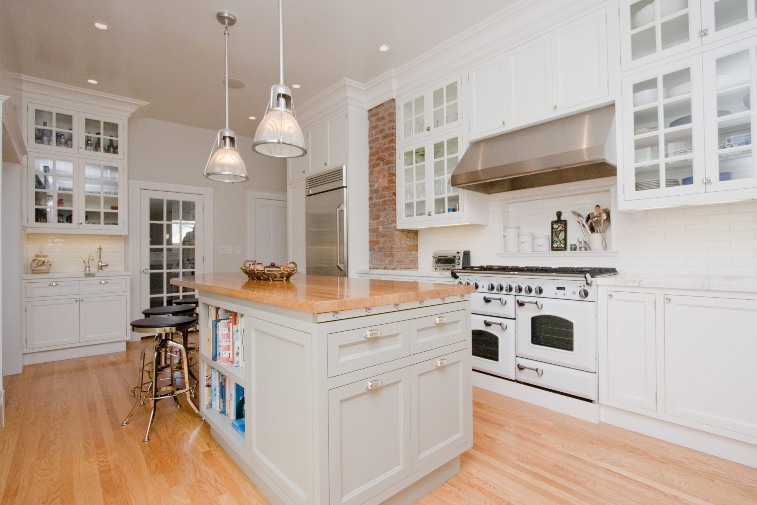 Modern kitchen interior with white cabinetry, stainless steel appliances, and a central island.