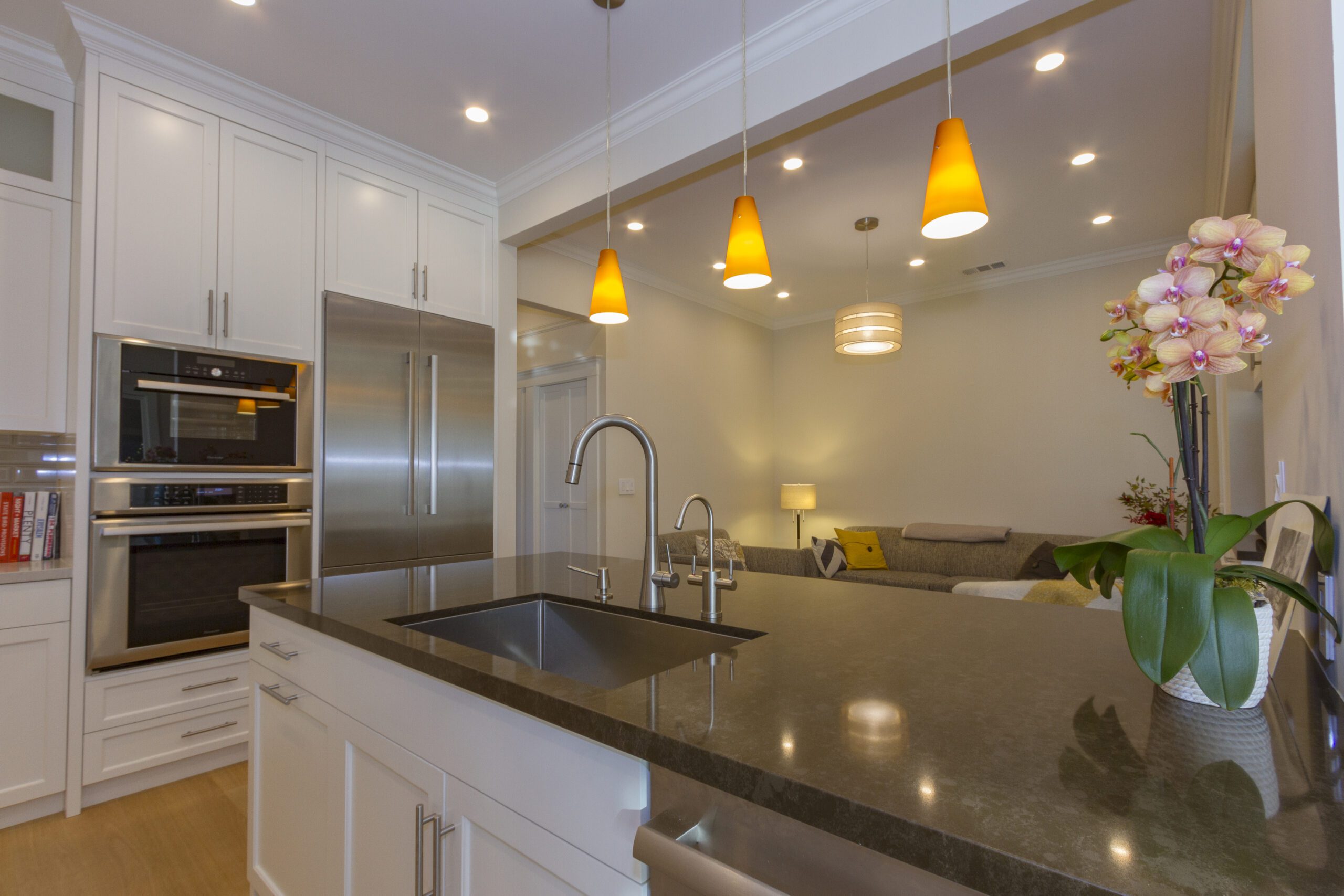 Modern kitchen with stainless steel appliances, white cabinetry, and pendant lighting over an island countertop.