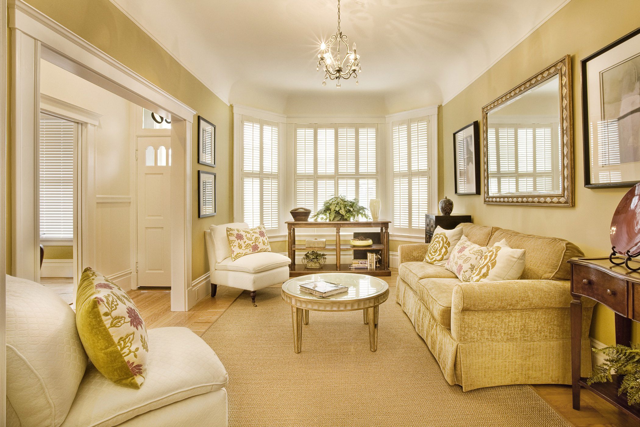 Elegant living room with natural light, featuring neutral tones and classic furnishings.